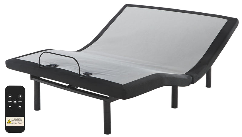 An adjustable bed frame with an Ashley Sleep® 1100 Series Hybrid Mattress, featuring a remote control. The bed is in an inclined position and includes black side and leg supports.